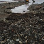 excavator dredging the channel to the ocean